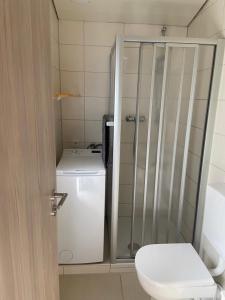 a bathroom with a toilet and a glass shower at Ferienhaus D52 Europa Feriendorf 2-6 Personen in Lichtenau