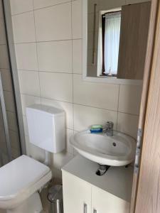 a bathroom with a sink and a toilet and a mirror at Ferienhaus D52 Europa Feriendorf 2-6 Personen in Lichtenau