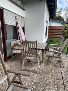 three wooden chairs and a picnic table with a hammock at Ferienhaus D52 Europa Feriendorf 2-6 Personen in Lichtenau