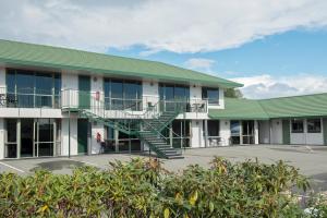 un edificio con techo verde y escalera en ASURE Ashley Motor Lodge en Timaru