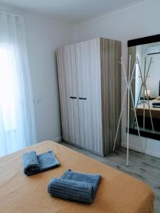 a bedroom with a bed with two blue pillows on it at Casa Doce in Olhão