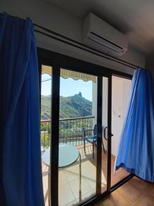 a room with a balcony with a view of a mountain at Apartamentos el Motor Tejeda in Tejeda