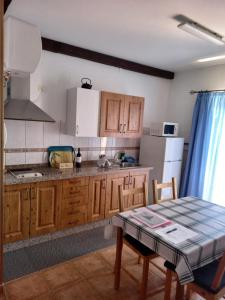 a kitchen with a table and a white refrigerator at Apartamentos el Motor Tejeda in Tejeda