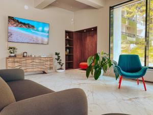 a living room with a couch and a tv on the wall at Hotel Corina in Venus