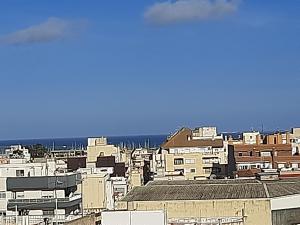 - une vue sur la ville avec ses bâtiments et l'océan dans l'établissement Àtic RENDILLA, à Sant Carles de la Ràpita