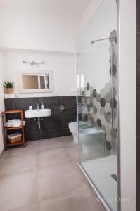 uma casa de banho com um chuveiro, um lavatório e um WC. em NEW HOME - appartamento in centro storico em Cagliari