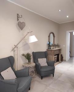 a living room with two chairs and a fireplace at NEW HOME - appartamento in centro storico in Cagliari