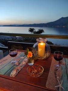 a table with a candle and two glasses of wine at Seaside Sunset in Korinthos