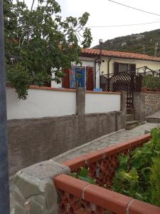 a stone retaining wall with a house in the background at Panorama in La Guardia