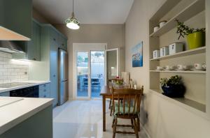 cocina con armarios verdes y mesa de madera en Lucas Apartment en Lixouri