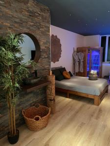- une chambre avec un lit et un mur en briques dans l'établissement Sweet love exotique by Locations_lepuyenvelay, à Brives-Charensac