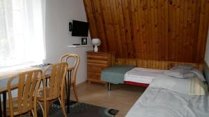 a bedroom with a bed and a table and chairs at Pokoje DAJAN in Łeba