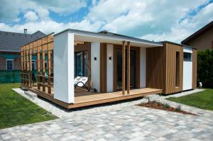 una pequeña casa con terraza en un patio en Villa Aquamarine en Balatonboglár