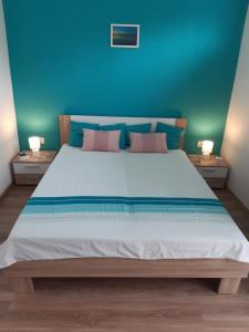 sypialnia z dużym białym łóżkiem z niebieskimi ścianami w obiekcie Villa Aquamarine w mieście Balatonboglár