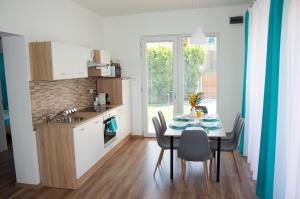 a kitchen with a table with chairs and a sink at Villa Aquamarine in Balatonboglár