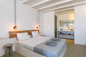 a bedroom with a large white bed with two towels on it at Ultramare Superior Suites with Seaview in Mýkonos City