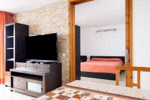a bedroom with a bed and a flat screen tv at Looking the VIEWS - 214 in Costa Del Silencio