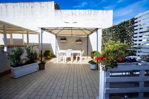 un patio con mesa, sillas y plantas en Trapani Home, en Trapani