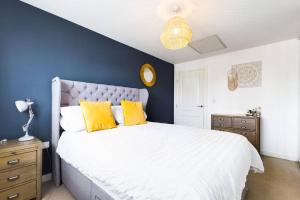 um quarto com uma grande cama branca com almofadas amarelas em Chic City Centre Apartment With Allocated Parking em Swansea
