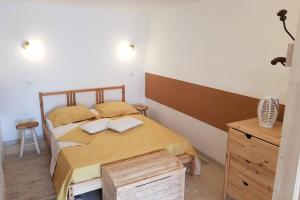 una camera da letto con letto con lenzuola gialle e testiera in legno di Cocon chic au pied du Vercors avec parking a Marches