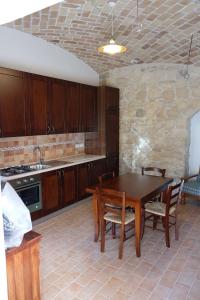 カラマーニコ・テルメにあるCasale Albericoのキッチン(木製のテーブル、椅子、カウンター付)