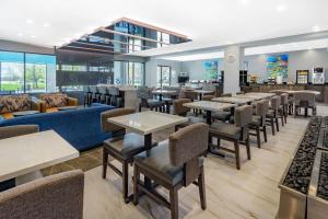 a restaurant with tables and couches and chairs at Wingate by Wyndham Tinley Park in Tinley Park