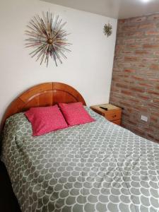 a bedroom with a bed with two pink pillows at Mini suites en el mejor sector de la ciudad in Quito
