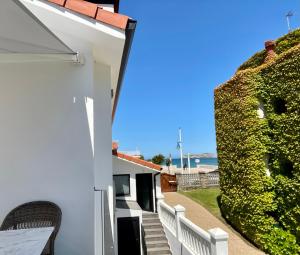 a white house with a ivy covered wall at La Playa Suites Suances in Suances