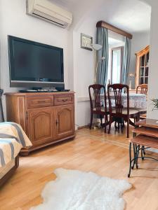 a living room with a large television and a dining table at Apartma Mandala in Koper