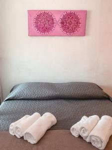 a bed with two white towels and two pink frames at Apartma Mandala in Koper