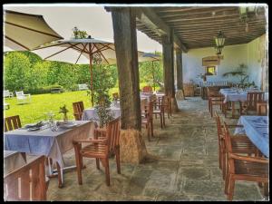 un ristorante con tavoli e sedie con ombrelloni di Palación de Toñanes a Toñanes