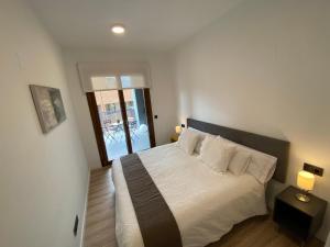 a bedroom with a bed with white sheets and pillows at Vianetto Home in Monzón