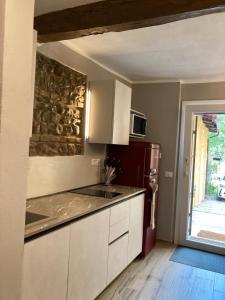 eine Küche mit weißen Schränken und einem roten Kühlschrank in der Unterkunft Delica in Zola Predosa