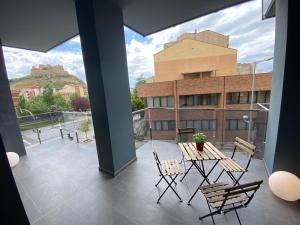a balcony with a table and chairs and a building at Vianetto Home in Monzón