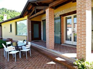 een patio met een tafel en stoelen op een bakstenen patio bij Brigida in Verucchio