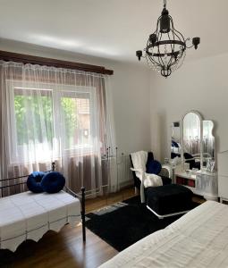 - une chambre avec un lit et un lustre dans l'établissement Gyere be Vendégház, à Drégelypalánk