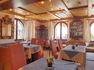 a dining room with tables and chairs and windows at Hotel Strand-Cafe direkt am Bodensee in Meersburg