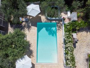 una vista aérea de una piscina con sombrillas en La Casèdde, en Cisternino