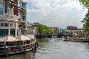 a boat on a river in a city at B&B The Catch Apartment in Amsterdam
