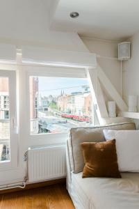 a living room with a couch and a large window at B&B The Catch Apartment in Amsterdam