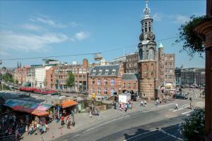 a city with a clock tower and a street with people at B&B The Catch Apartment in Amsterdam