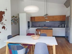 a kitchen with a white table and chairs at 3,5 Zimmer Dachwohnung: Modern, komfortabel, zentral, mit Bergsicht in Disentis