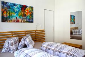 1 dormitorio con sofá y una pintura en la pared en 3,5 Zimmer Dachwohnung: Modern, komfortabel, zentral, mit Bergsicht en Disentis