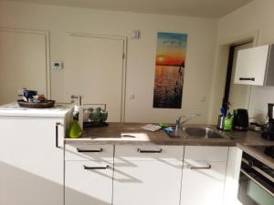 a kitchen with white cabinets and a sink at Seestern - Ferienhaus am Quendorfer See (Nr. 5) in Schüttorf +26 photos