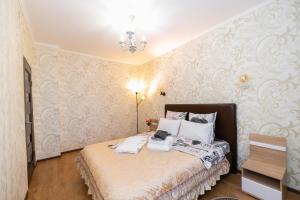 1 dormitorio con 1 cama en una habitación con papel pintado en В Promenade Expo квартира с романтическим видом, en Astana