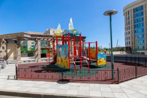 einen Spielplatz mit Rutsche in einer Stadt in der Unterkunft В Promenade Expo квартира с романтическим видом in Astana