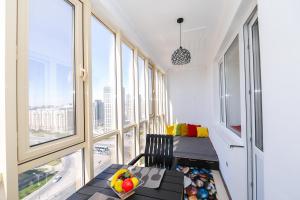 una habitación con ventanas y una mesa con fruta. en В Promenade Expo квартира с романтическим видом, en Astana