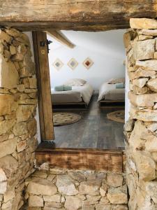 2 Betten in einem Zimmer mit einer Steinmauer in der Unterkunft La maison coup de cœur de Pont Caffino in Maisdon-sur-Sèvre