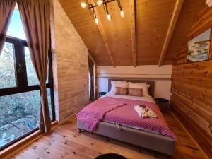 a bedroom with a bed in a room with wooden walls at OLEA COTTAGE in Ulcinj