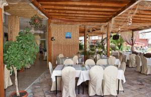 een eetkamer met witte tafels en witte stoelen bij Privilege Fort Beach - Sea Viev Premium Apartments in Elenite